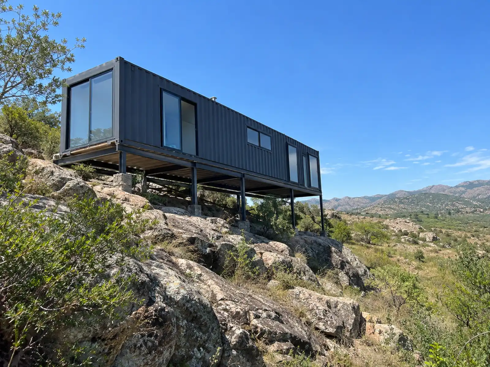 Estructura metálica anclada a la roca bajo una casa container en Tanti