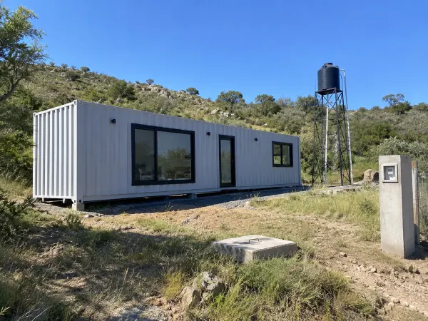 Casa container con tanque sobre torre y pilar de luz en Sierras Chicas