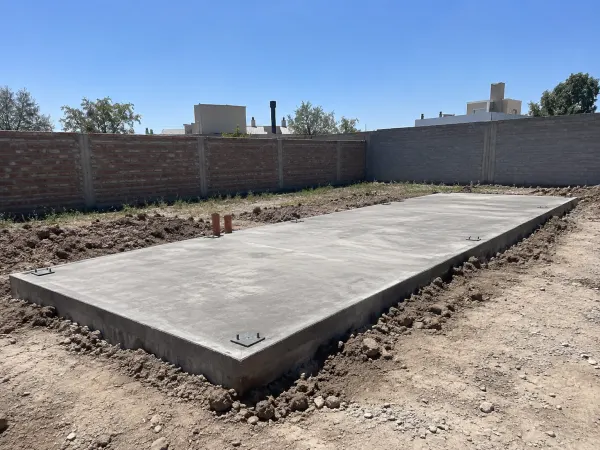 Platea de hormigón con placas de anclaje para una casa container